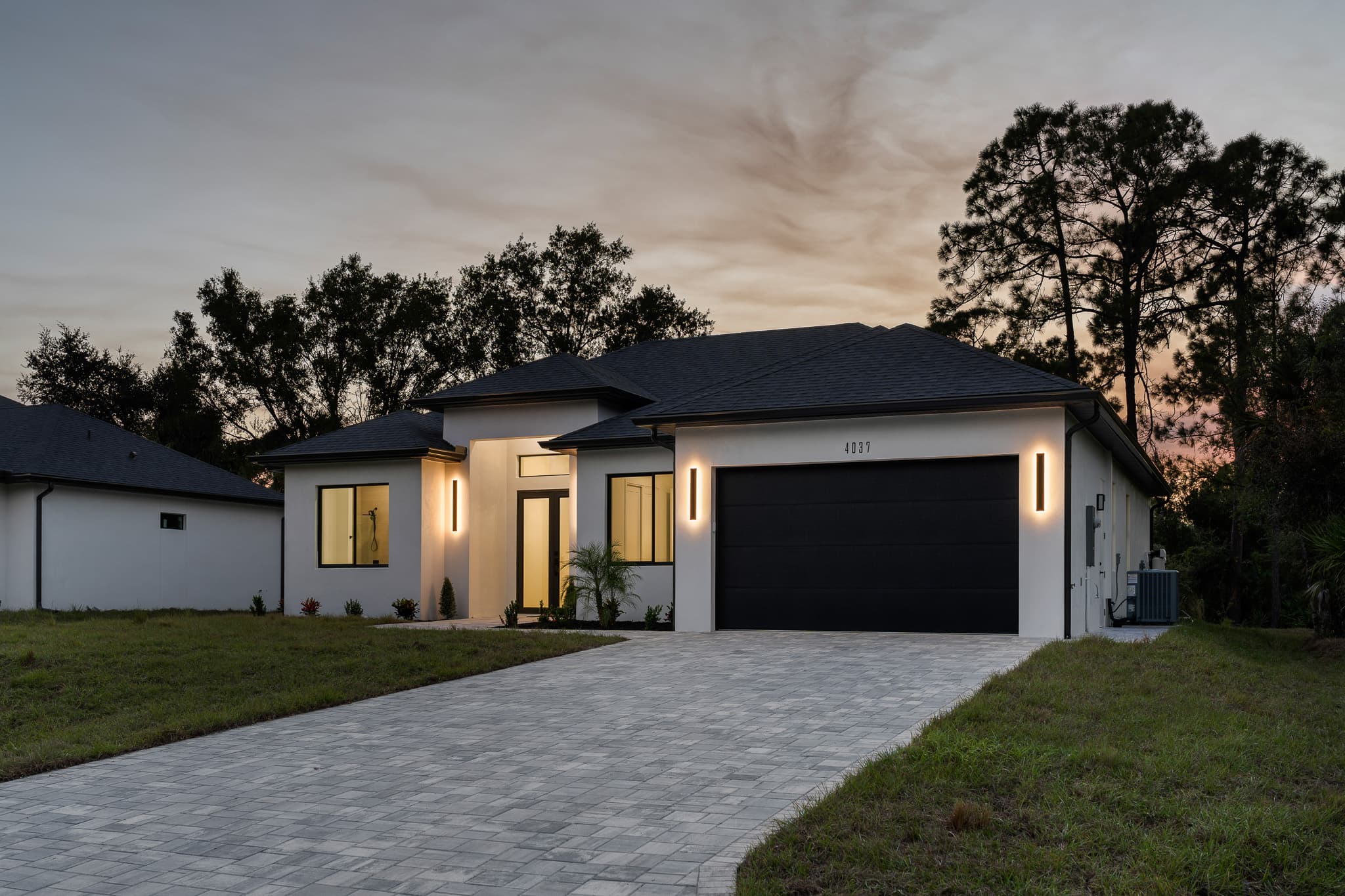 Contemporary custom home exterior at dusk — Tailored Build